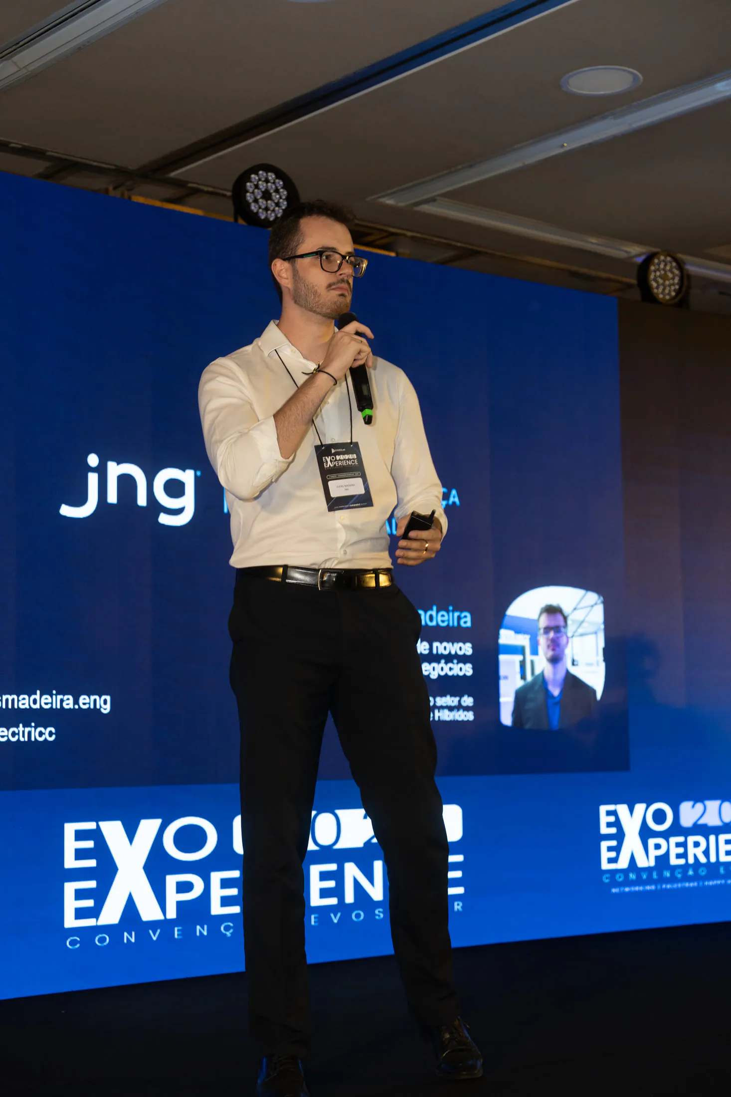 Lucas Madeira abrindo a palestra no palco da convenção de 2026, com seu nome e seu cargo no telão