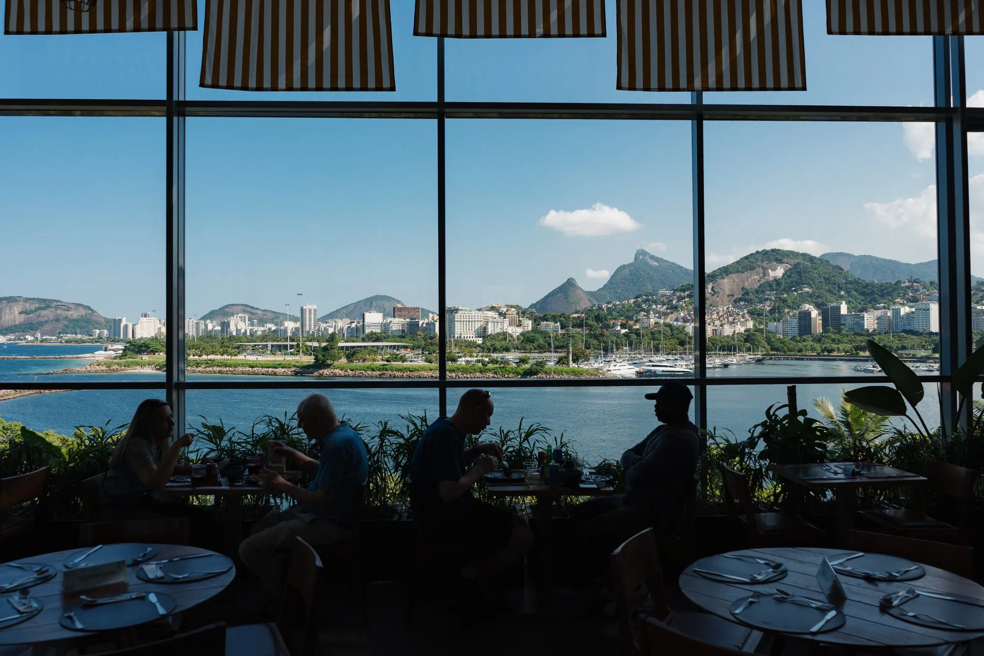 Bar do Prodigy Santos Dumont com mesas de frente para a Baía de Guanabara